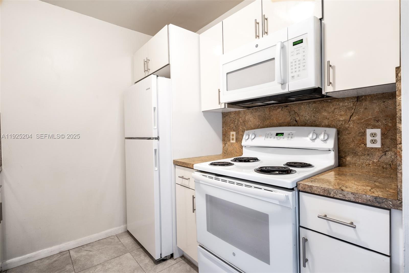 100 Southwest 132nd Way, Unit 306K Pembroke Pines, FL 33027 - Photo 8 of 31 a kitchen with granite countertop cabinets stainless steel appliances and a counter space