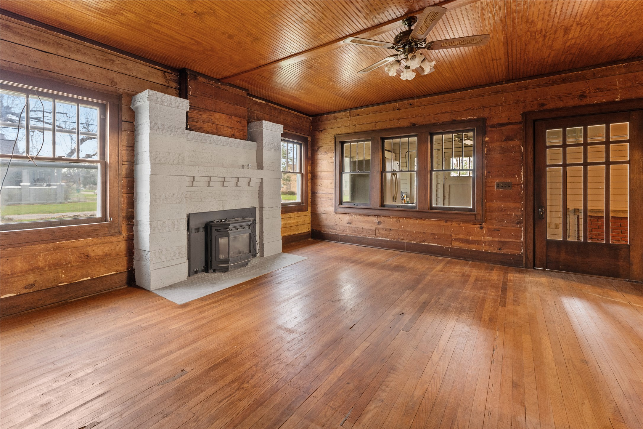 501 East 6th Street Cameron, TX 76520 - Photo 16 of 39 Unfurnished living room with ceiling fan, wooden walls, hardwood / wood-style floors, and wooden ceiling