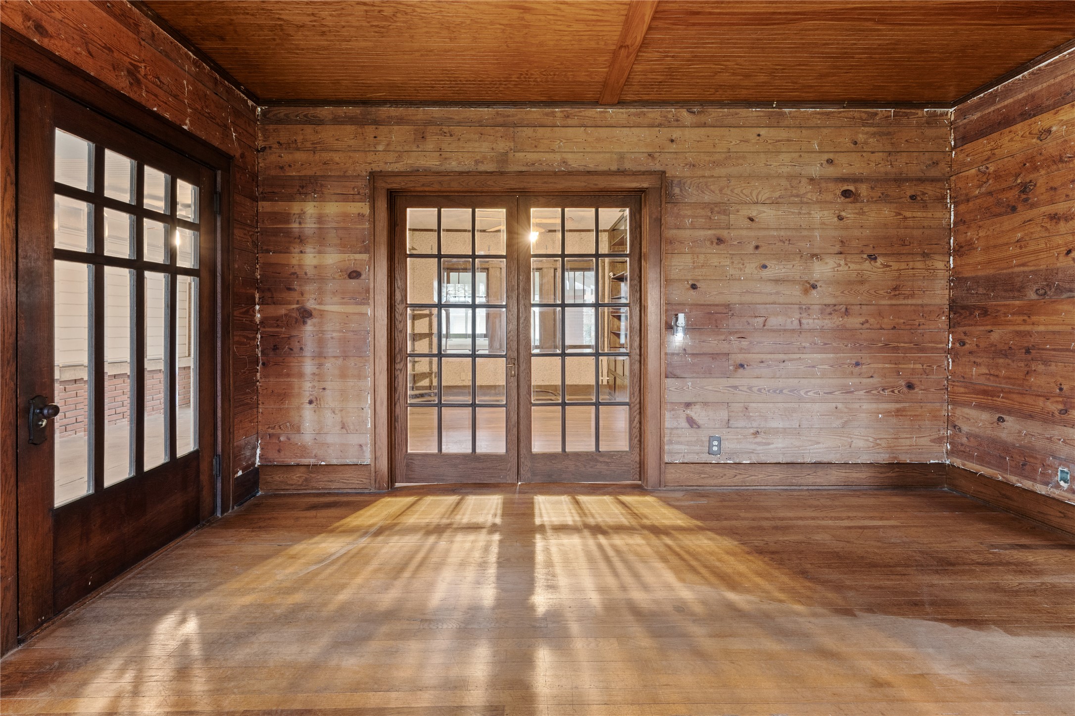 501 East 6th Street Cameron, TX 76520 - Photo 20 of 39 Spare room featuring wooden walls, french doors, wood ceiling, and wood finished floors