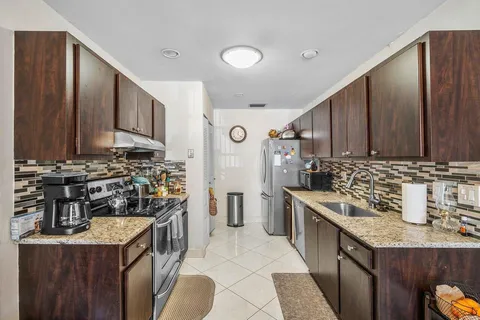 a kitchen with stainless steel appliances granite countertop a stove a sink and a refrigerator