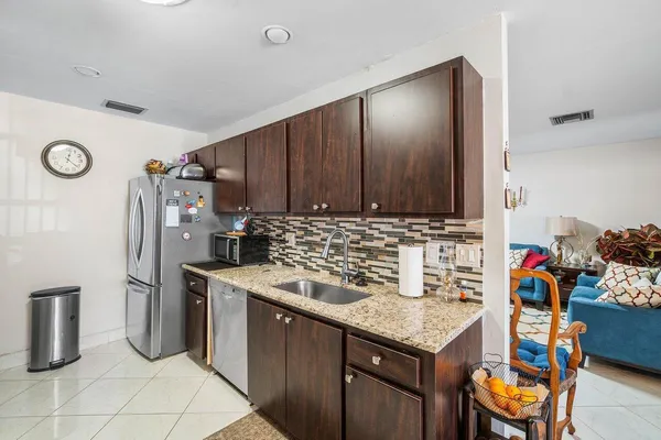 a kitchen with stainless steel appliances granite countertop a refrigerator and a stove top oven