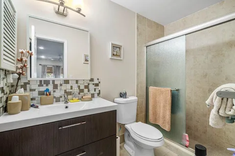 a bathroom with a sink a toilet a mirror and shower