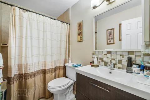 a bathroom with a sink a toilet and a mirror