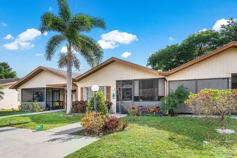 a view of a house with a yard and potted plants