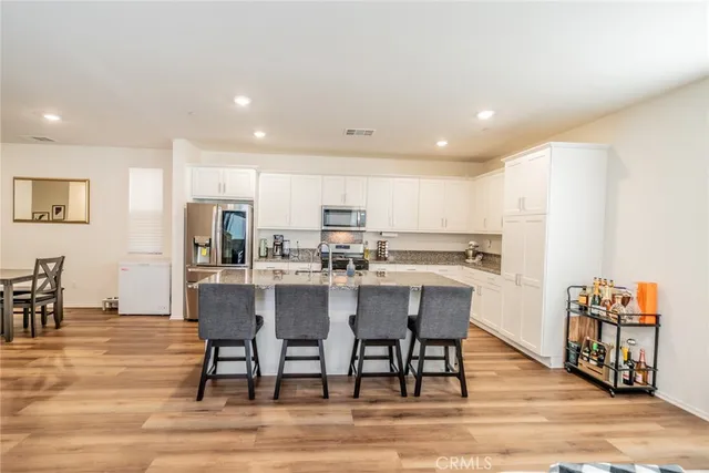 a dining room with stainless steel appliances wooden floor dining table and chairs