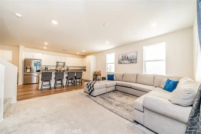 a living room with furniture and view of kitchen
