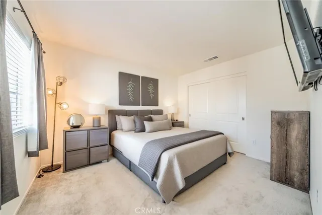 a bedroom with a bed and a painting on the wall