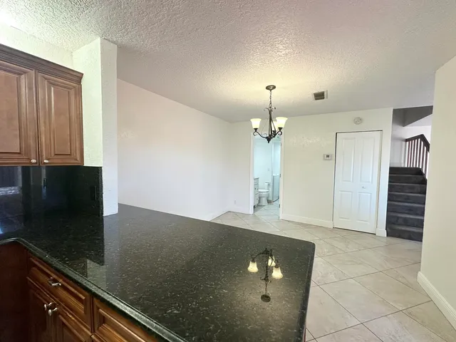 an empty room with wooden floor and cabinet