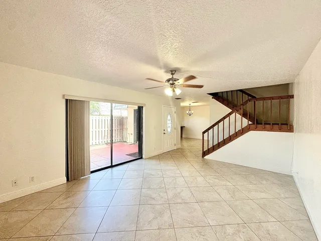 an empty room with a ceiling fan and a window