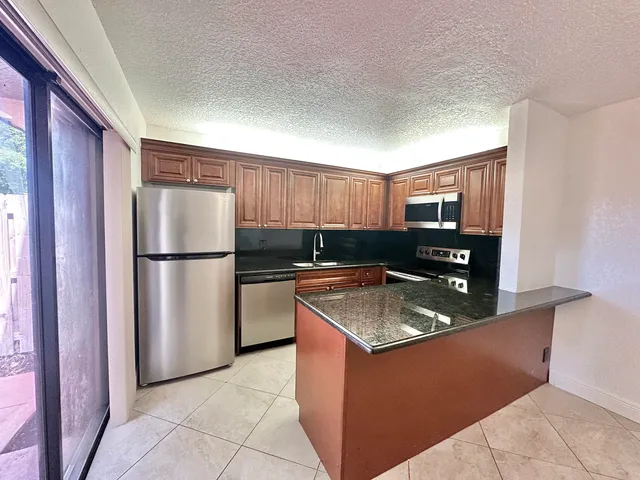 a kitchen with stainless steel appliances granite countertop a refrigerator and a sink