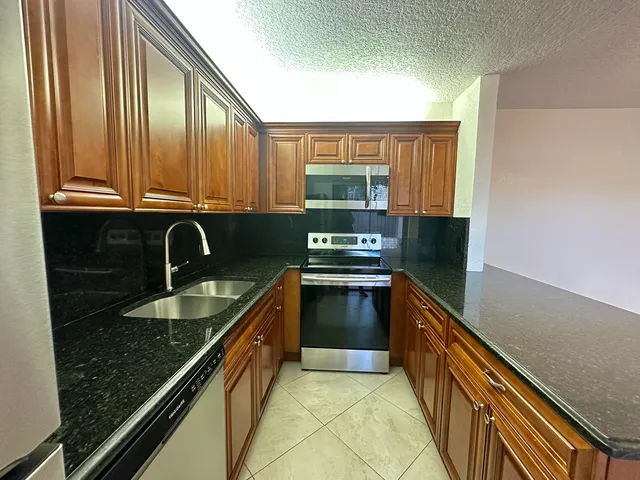 a kitchen with stainless steel appliances granite countertop a sink and a stove