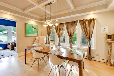 a dining room with furniture and a floor to ceiling window