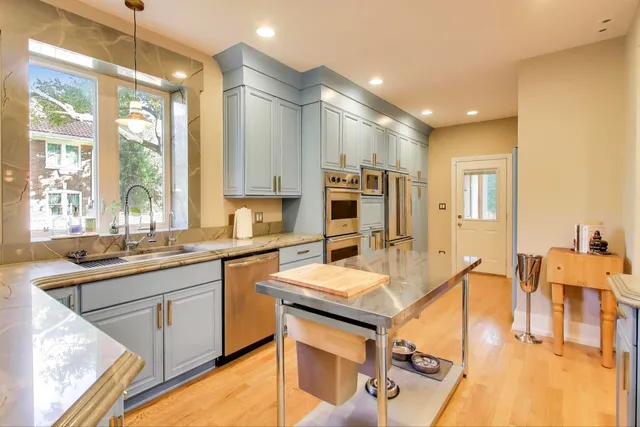 a kitchen with stainless steel appliances granite countertop a stove a sink and a microwave