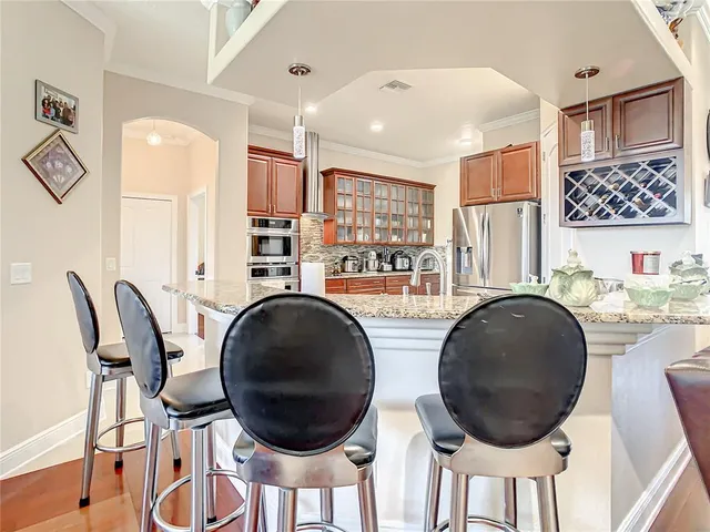 a large kitchen with cabinets a sink and stainless steel appliances