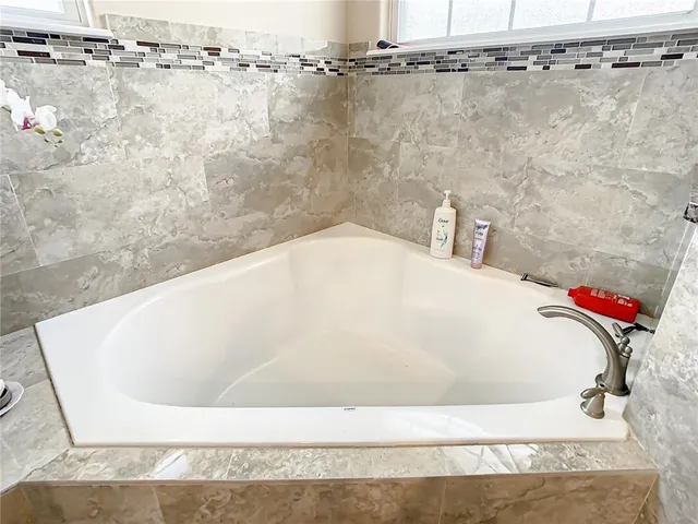 a bedroom with a bed and large mirror with a bathtub