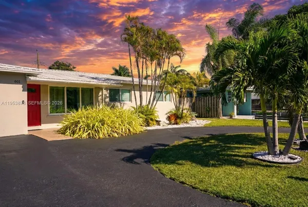 a view of a house with backyard and sitting area