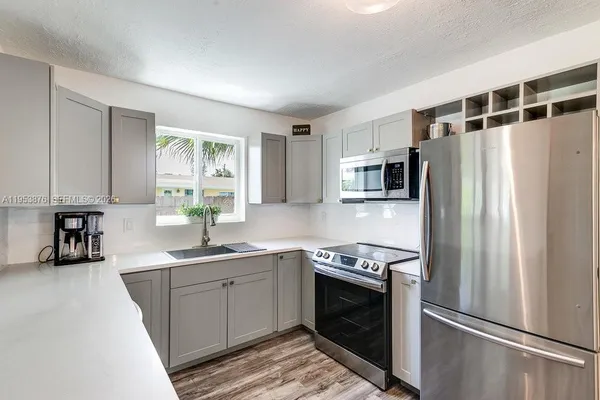 a kitchen with stainless steel appliances a refrigerator sink and microwave