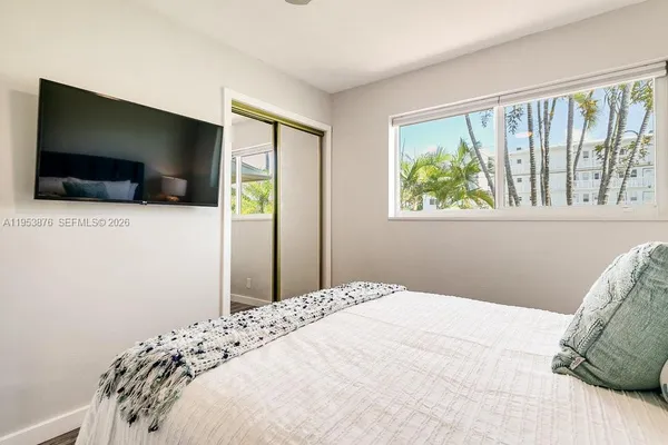 a bedroom with a bed and a flat screen tv