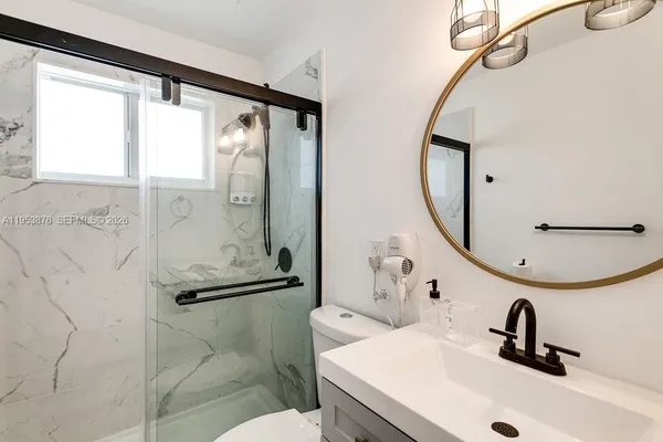 a bathroom with a sink mirror and a shower