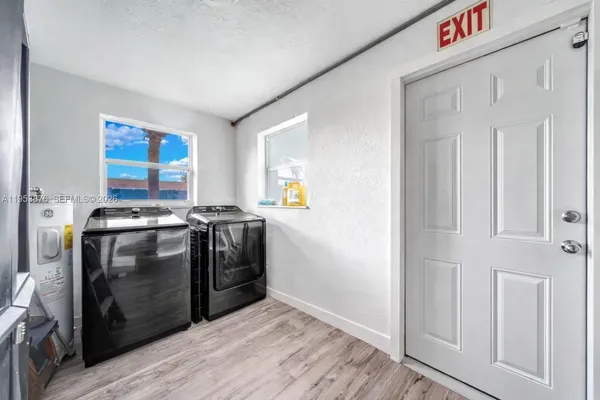 a view of a kitchen with fridge and wooden floor