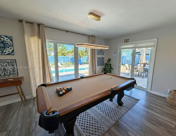 a room with pool table and windows