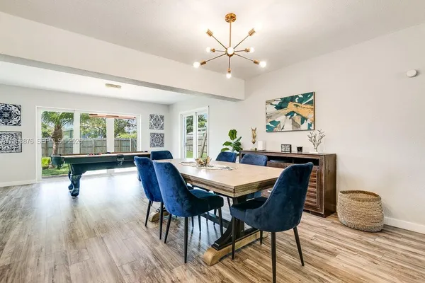 a dining room with furniture a large window and wooden floor