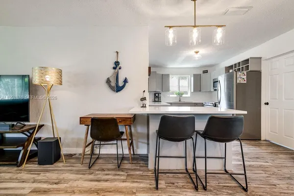 a kitchen with a dining table chairs and white cabinets
