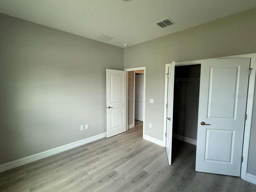 438 Awin Circle Southeast Palm Bay, FL 32909 - Photo 11 of 26 an empty room with wooden floor & closet area