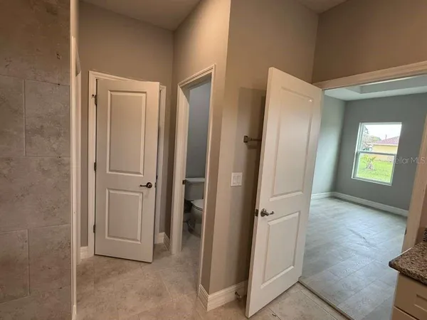 an empty room with wooden floor and a bathroom