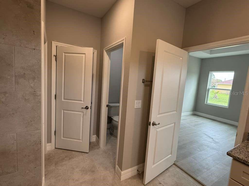 438 Awin Circle Southeast Palm Bay, FL 32909 - Photo 15 of 26 an empty room with wooden floor and a bathroom