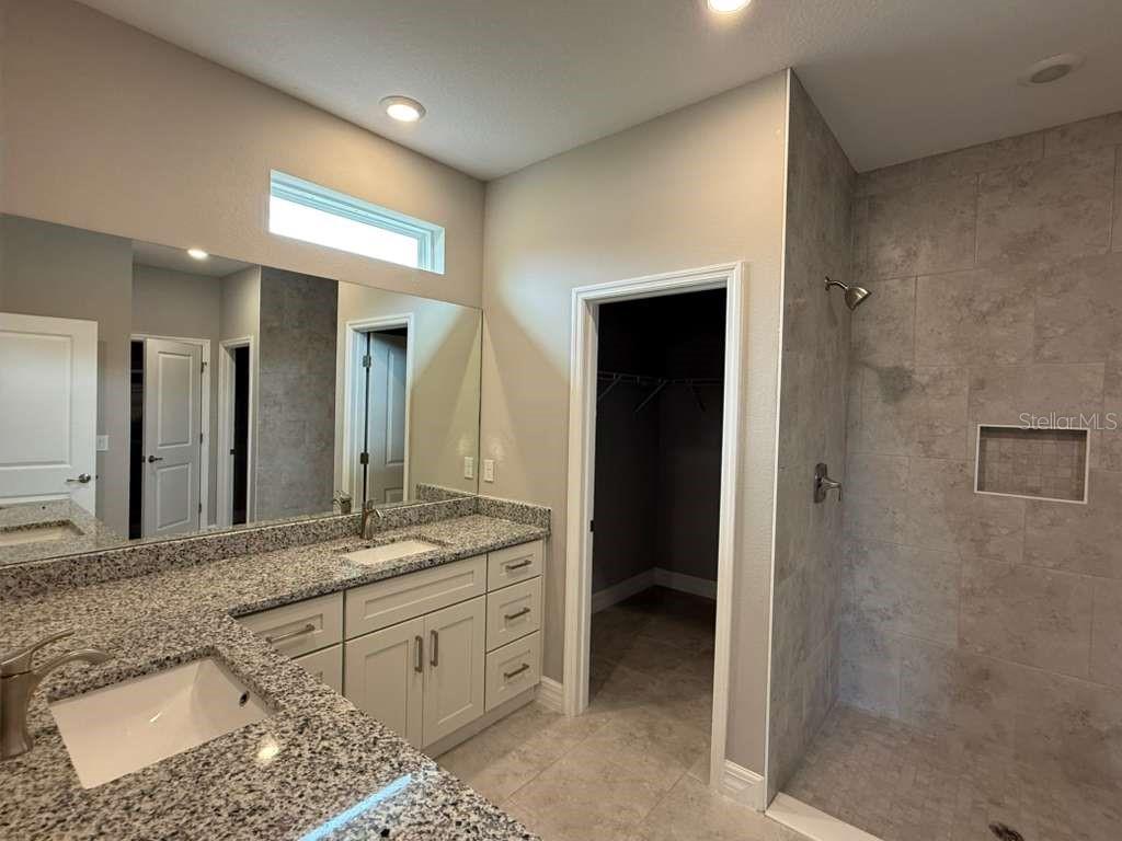 438 Awin Circle Southeast Palm Bay, FL 32909 - Photo 16 of 26 a spacious bathroom with a granite countertop sink and a mirror