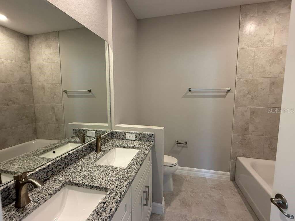 438 Awin Circle Southeast Palm Bay, FL 32909 - Photo 17 of 26 a bathroom with a granite countertop sink and a mirror