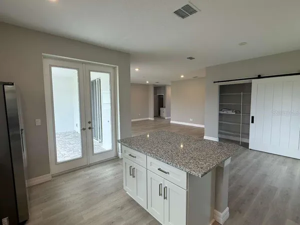 an empty room with wooden floor and hallway