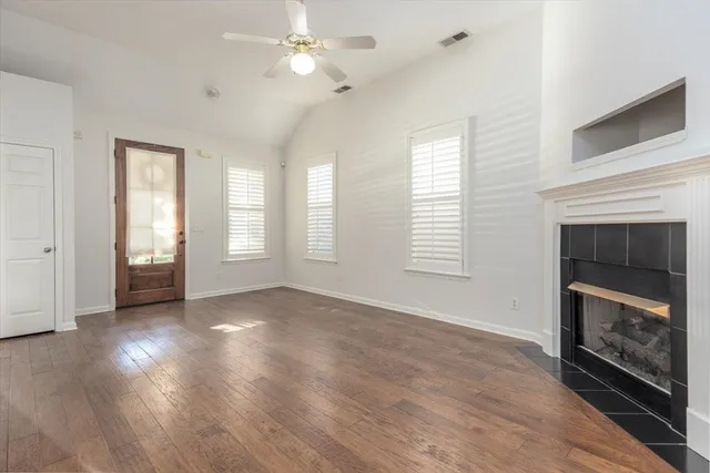 a view of an empty room with exposed radiator and fireplace
