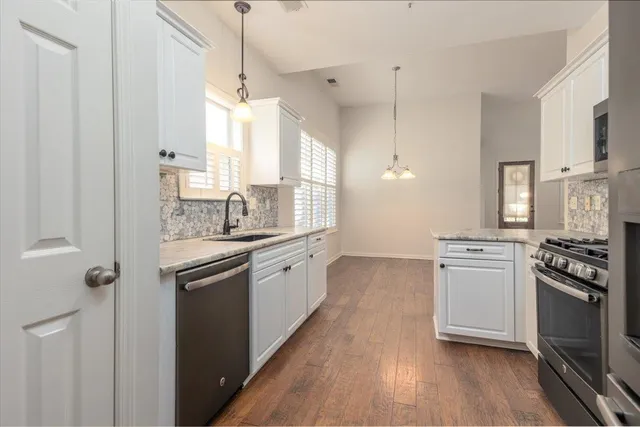 a kitchen with stainless steel appliances granite countertop a sink stove and refrigerator