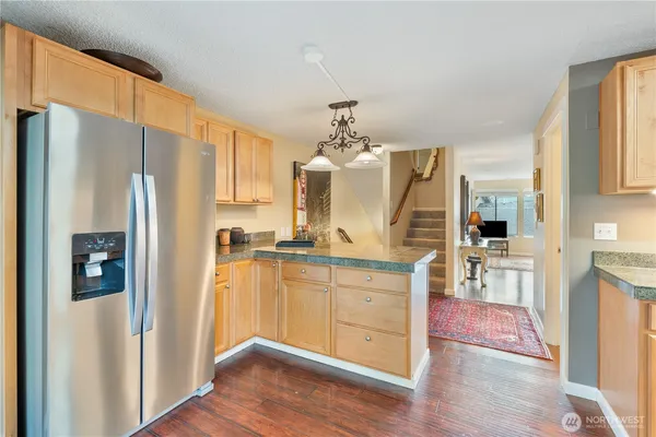 a kitchen with stainless steel appliances a refrigerator and wooden floor