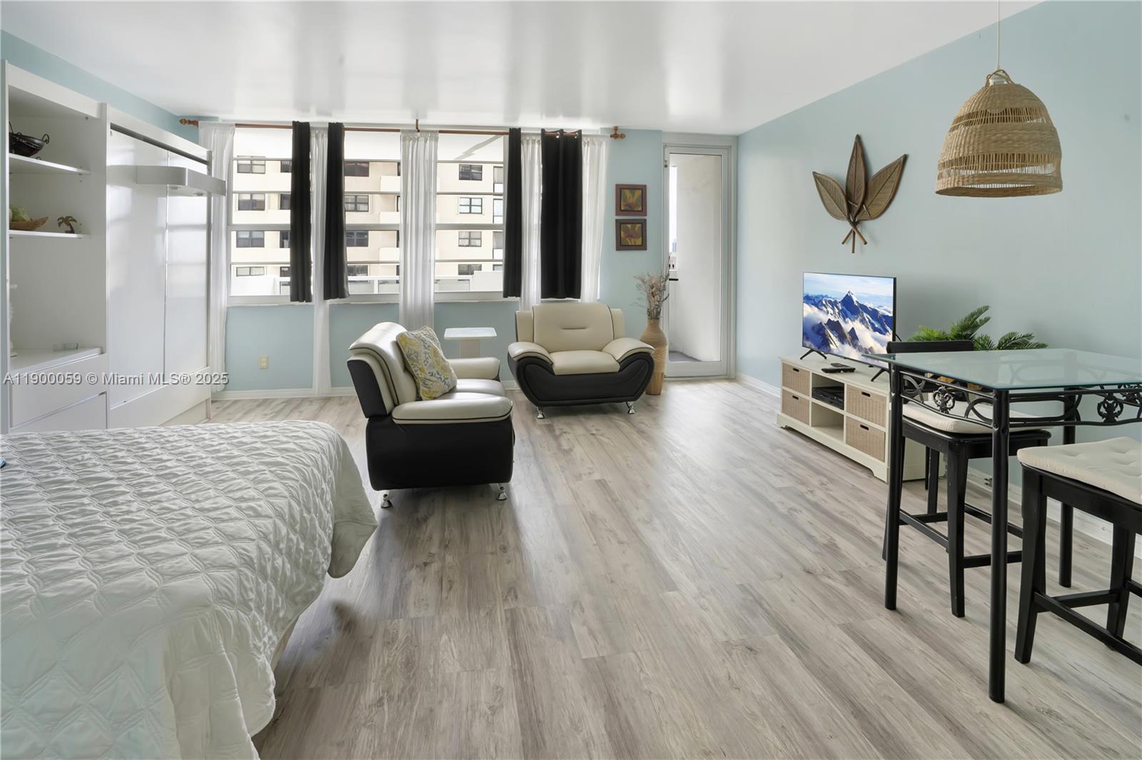 100 Lincoln Road, Unit 607 Miami Beach, FL 33139 - Photo 12 of 30 a bedroom with a bed a couch and dresser next to a window