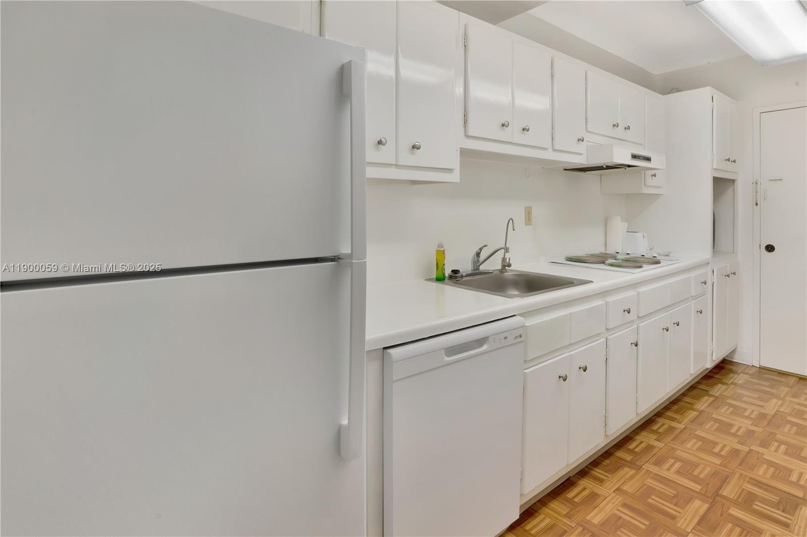 100 Lincoln Road, Unit 607 Miami Beach, FL 33139 - Photo 17 of 30 a kitchen with white cabinets and white appliances