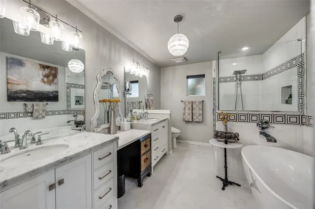 a large bathroom with a double vanity sink mirror and a bathtub