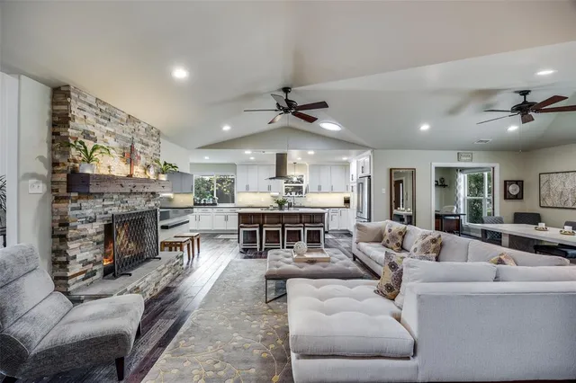 a living room with furniture a fireplace and a chandelier