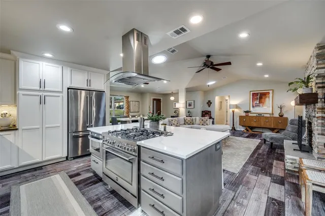 a large kitchen with a table chairs refrigerator and microwave