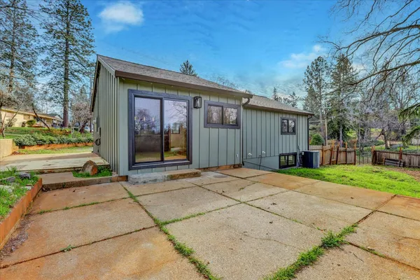 a view of a house with backyard and tree
