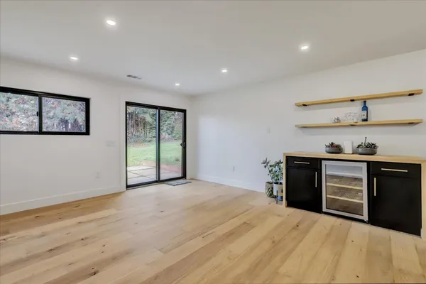 a large white kitchen with a large counter top stainless steel appliances and cabinets