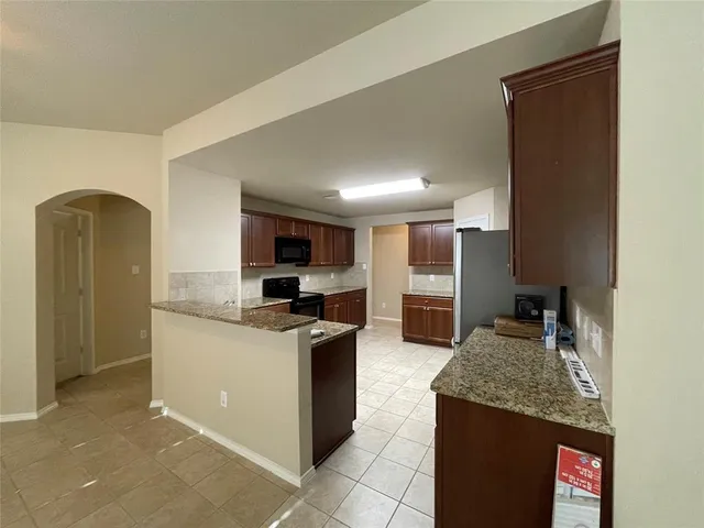 a kitchen with stainless steel appliances granite countertop a stove oven and a refrigerator