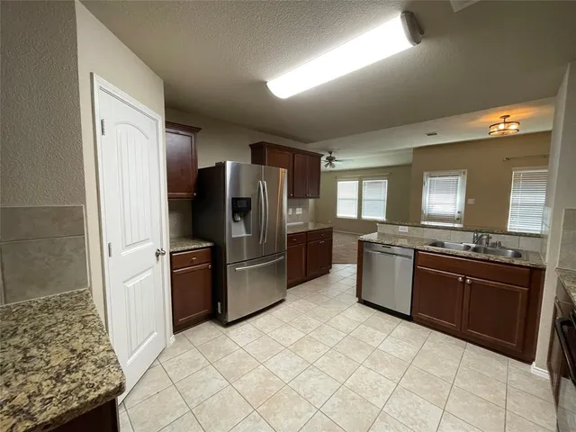 a kitchen with stainless steel appliances granite countertop a refrigerator and a stove