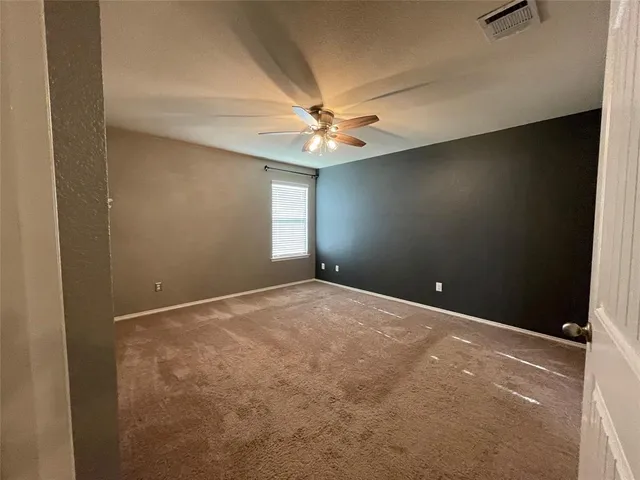 en empty room with windows and fan