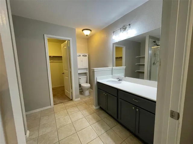 a spacious bathroom with a mirror sink and shower