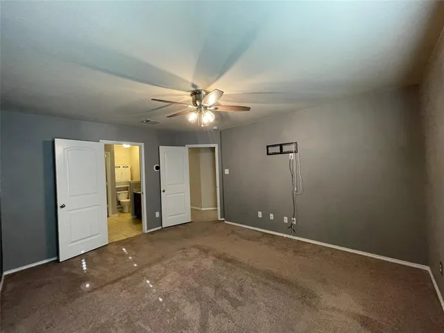 an empty room with closet and a chandelier fan