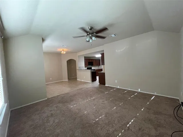en empty room with windows and ceiling fan
