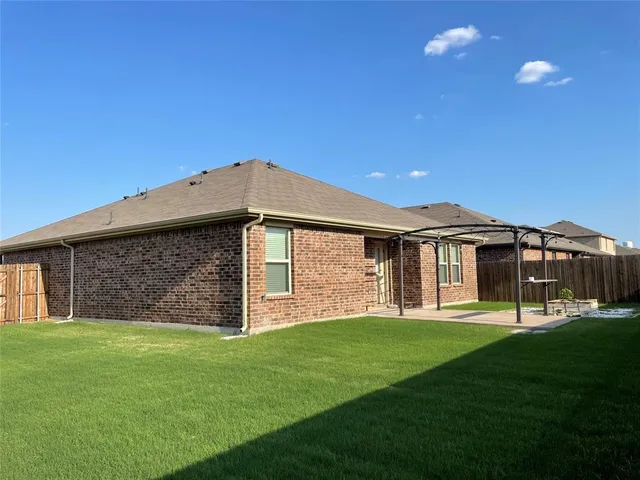 a view of a house with a yard and sitting area